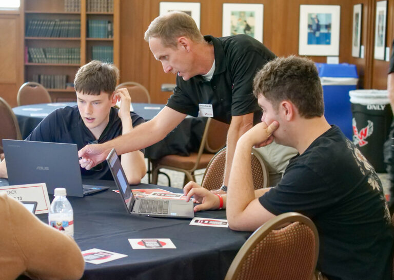 Two students working with a faculty member.