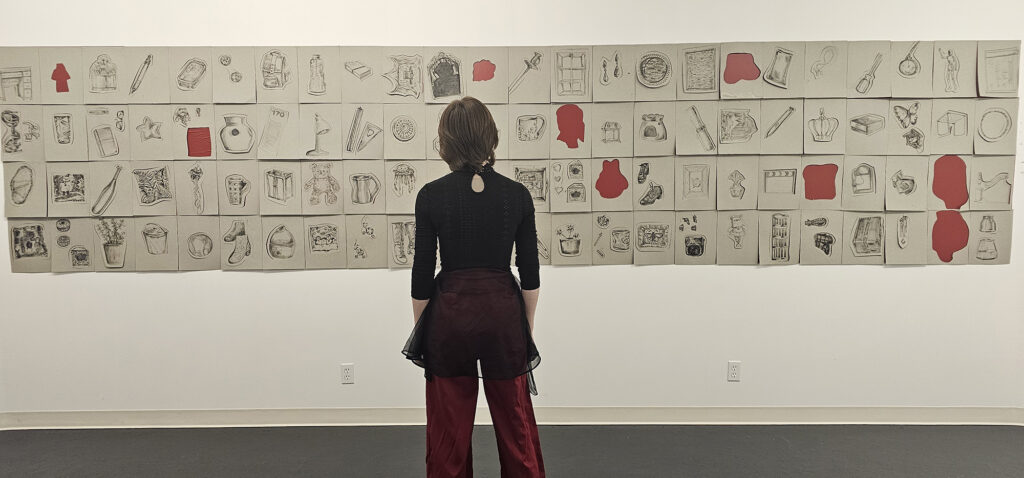 Travis Truly stands in front of his mural exhibit.