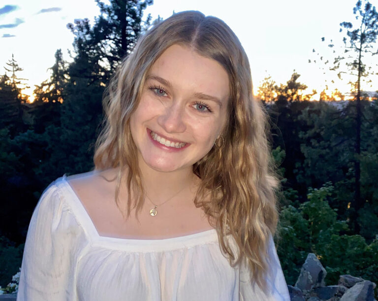 Kensi Nelson is pictured outdoors with trees in the background.