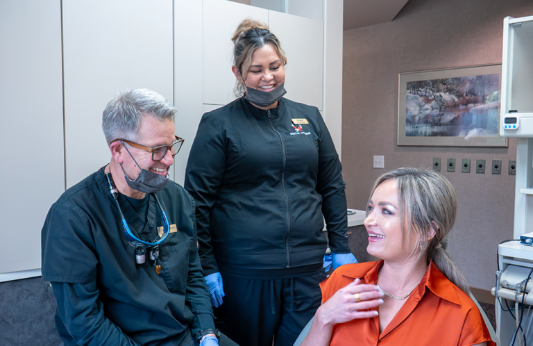 Dr. Ellingson pictured with an Eastern graduate he hired and a client at their Smile Source clinic.