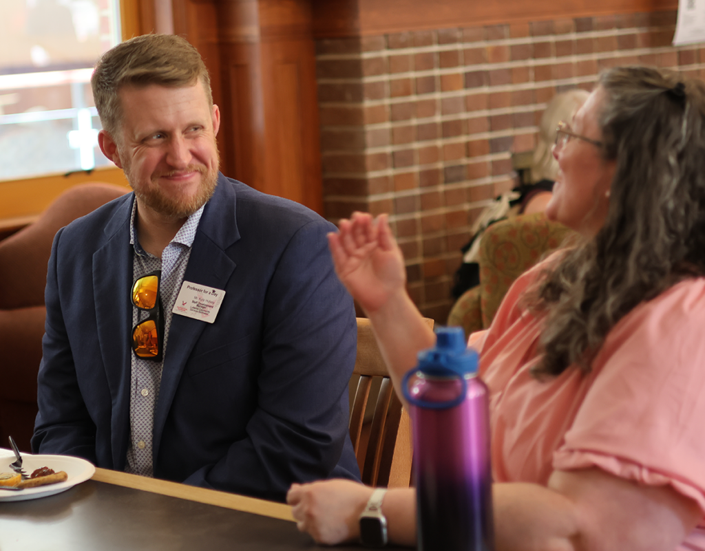 Guest professor talking with another person over lunch.
