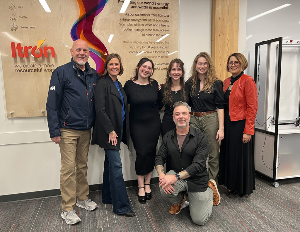 The Itron team and teh EWU team pose for a photo by the new sign.