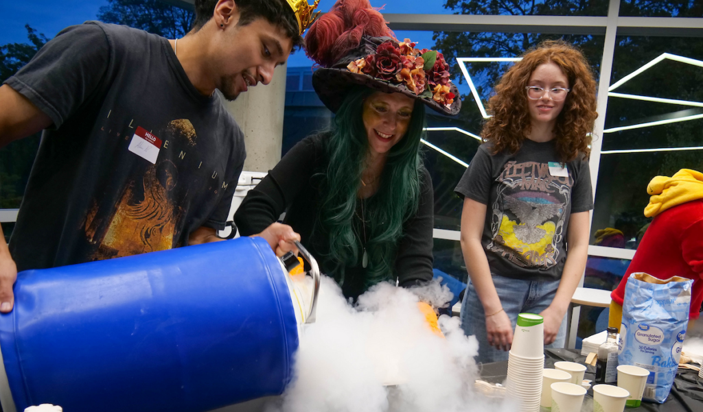 Spooky Science experiment with instructors and a student with a cauldron.