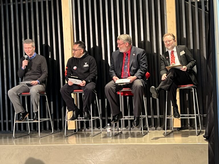 Leaders of the four colleges sitting on a stage at the Catalyst playing the "date-able" game.