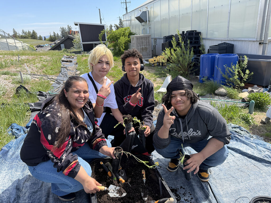 Group of middle schools students posing around plants