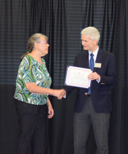 Photo of Debbie Moradi excepting her certificate honoring her retirement from Dean Brian Donahue